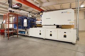 Wtryskarka Zhafir Zeres 3600 wraz z zamontowanym robotem w hali produkcyjnej, widoczne dodatkowa klatka bezpieczeństwa oraz suwnica.