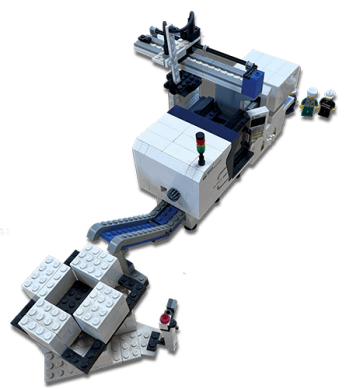 Model z klocków LEGO przedstawiający linię produkcyjną z wtryskarką obok maszyny widoczne figurki LEGO symbolizujące operatorów.